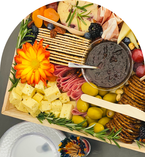 Cheese platter with fruits, crackers, and jam.