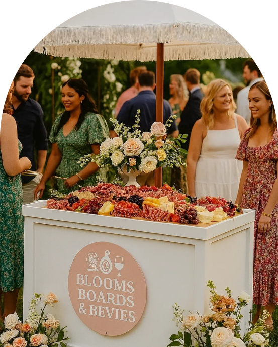 Outdoor gathering with charcuterie board and flowers.